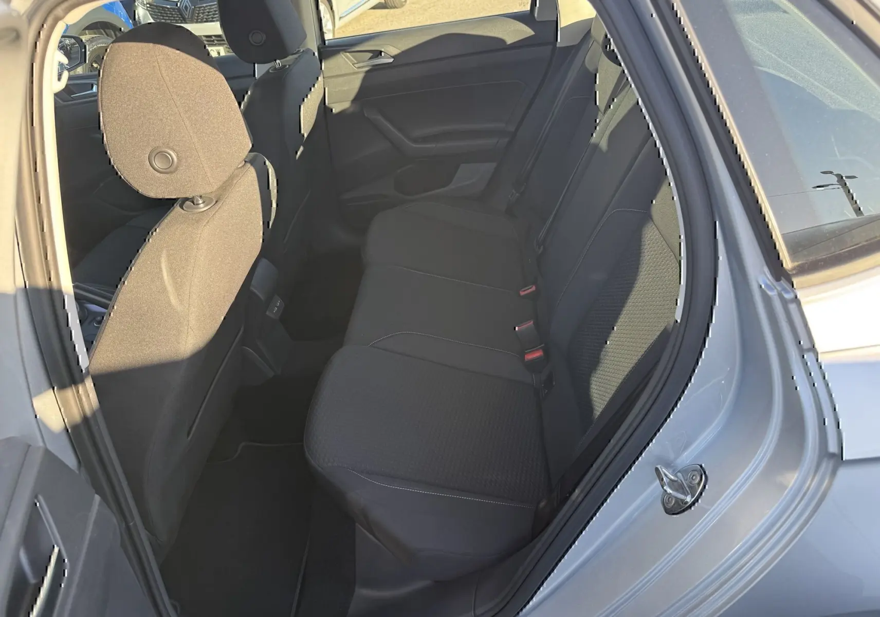 Vue intérieure côté arrière droit de la Volkswagen Polo gris métal 2021, montrant les sièges arrière et la porte ouverte.