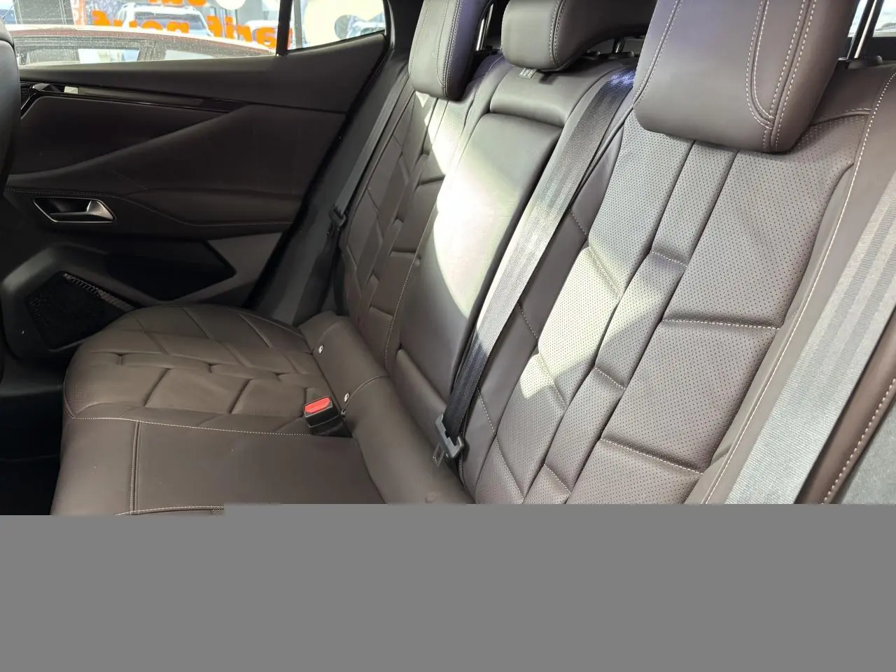 Vue latérale intérieure montrant la banquette arrière en cuir Nappa brun Criollo avec appuie-têtes et ceintures de sécurité.