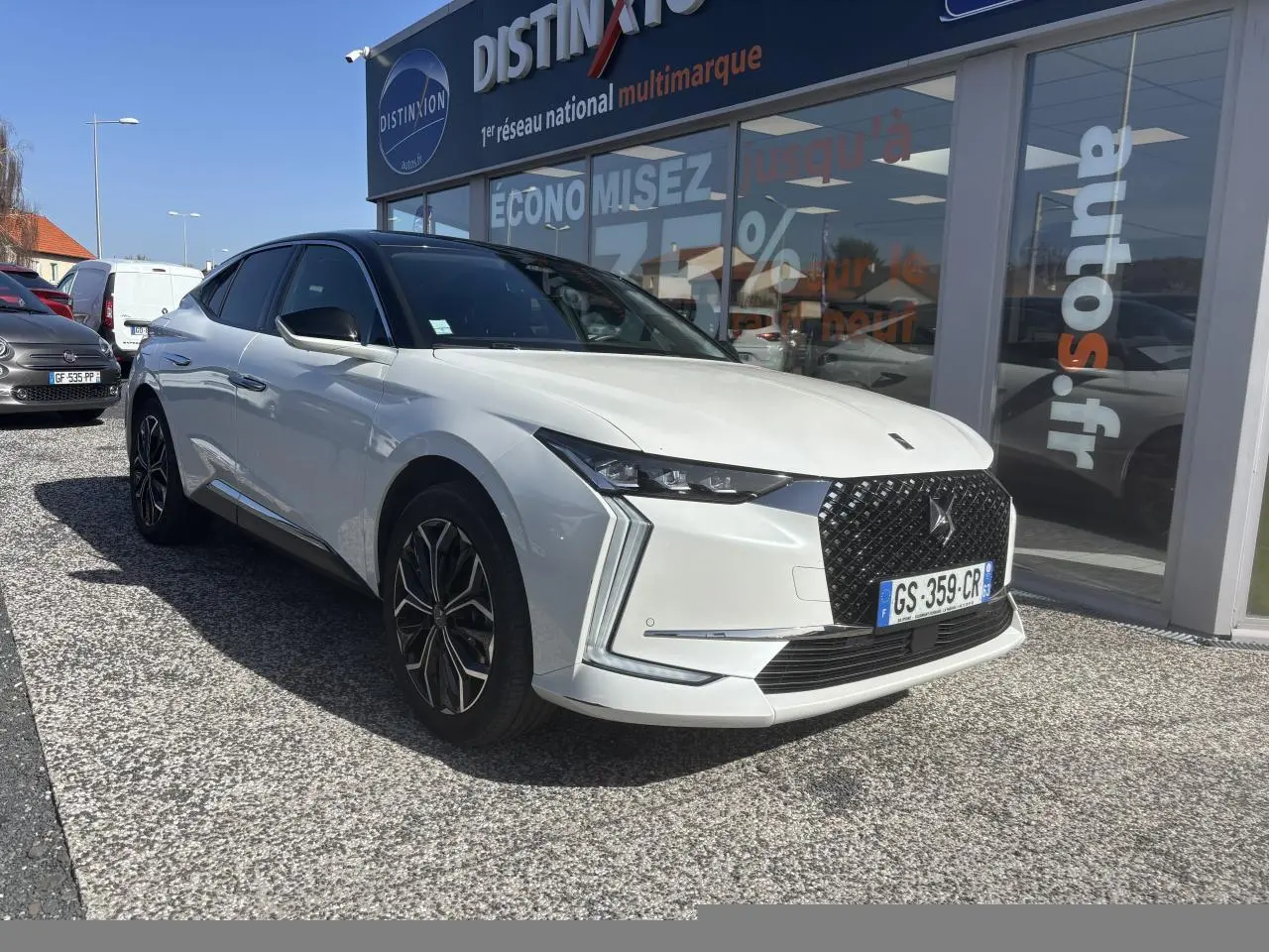 DS4 E-Tense 2023 vue 3/4 avant côté gauche, carrosserie blanche avec toit noir et calandre noire distinctive.
