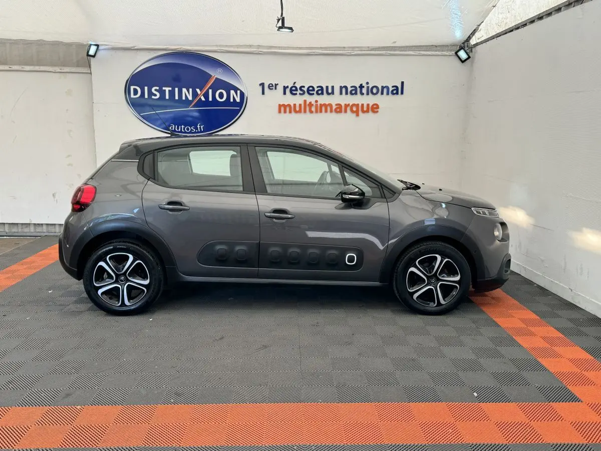 Vue de profil côté gauche d'une Citroën C3 gris foncé avec protections latérales noires et jantes bi-ton.