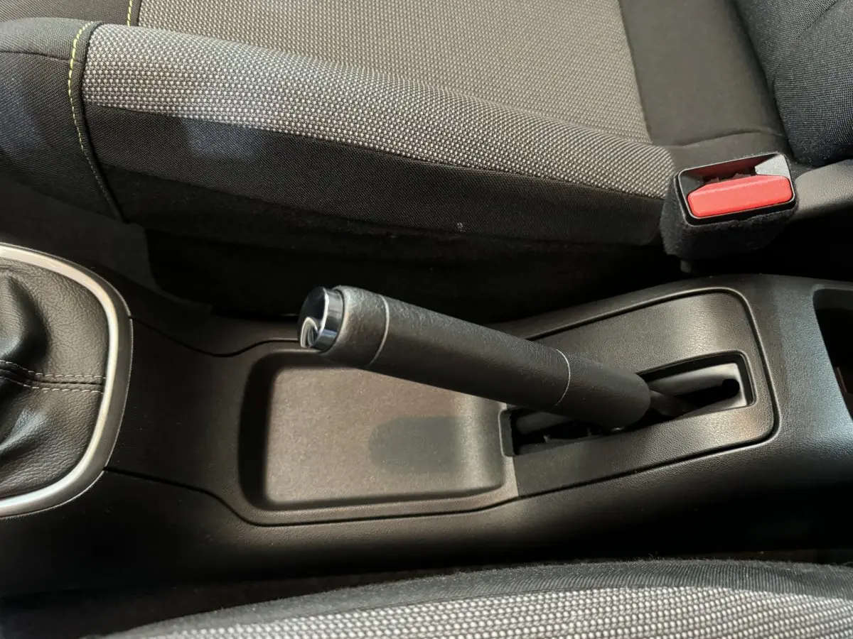 Vue rapprochée de la poignée de frein à main et de la ceinture de sécurité rouge dans l’habitacle gris foncé d’une Citroën C3 2020.