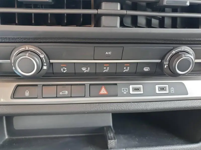 Vue rapprochée de la console centrale du Peugeot Expert Fourgon blanc, montrant les commandes de climatisation et les ports USB.