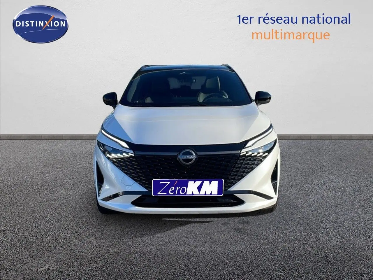 Vue frontale d'un Nissan Qashqai blanc nacré avec toit noir, mettant en valeur sa calandre noire et ses phares LED fins.