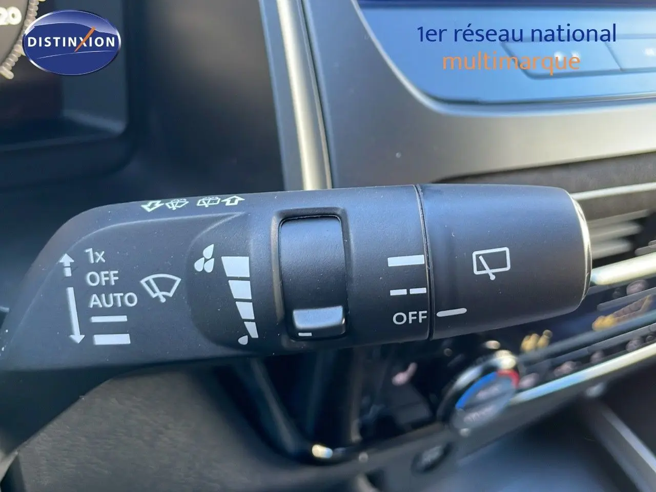 Gros plan sur la commande d'essuie-glace du Nissan Qashqai blanc nacré au toit noir, intérieur moderne.