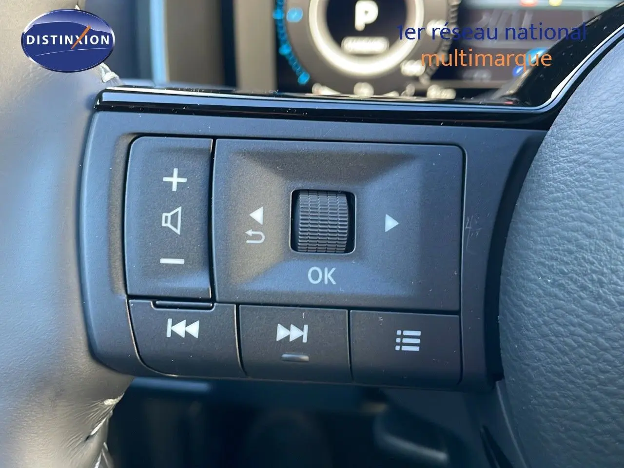 Gros plan sur les commandes au volant noir du Nissan Qashqai blanc nacré avec toit noir, version N-Design.