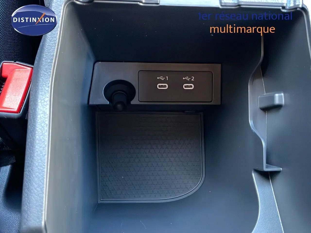 Gros plan sur la console centrale du Nissan Qashqai blanc nacré, montrant deux ports USB et un allume-cigare.