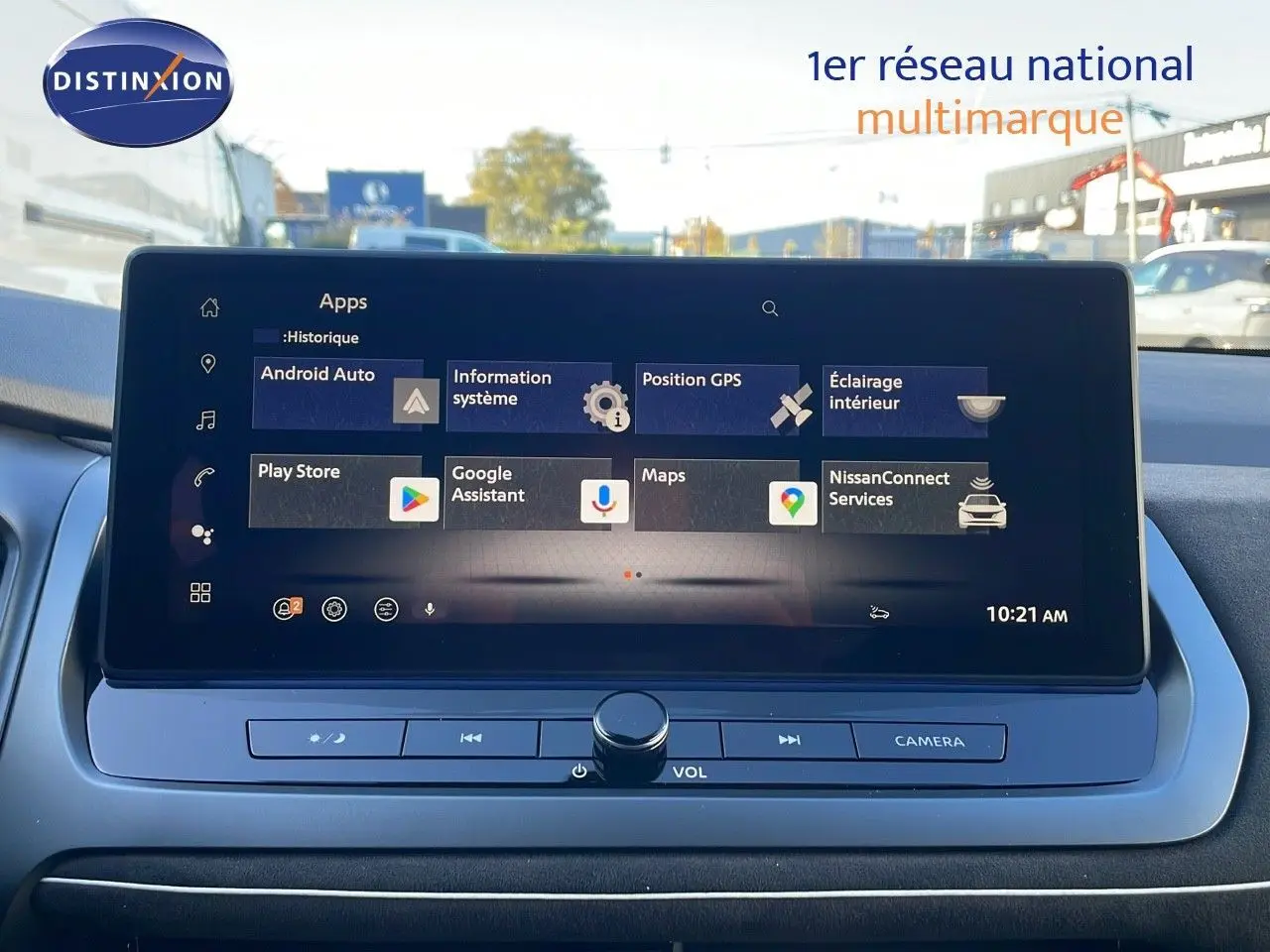 Écran tactile central affichant les applications connectées du Nissan Qashqai blanc nacré au toit noir, vue intérieure frontale.