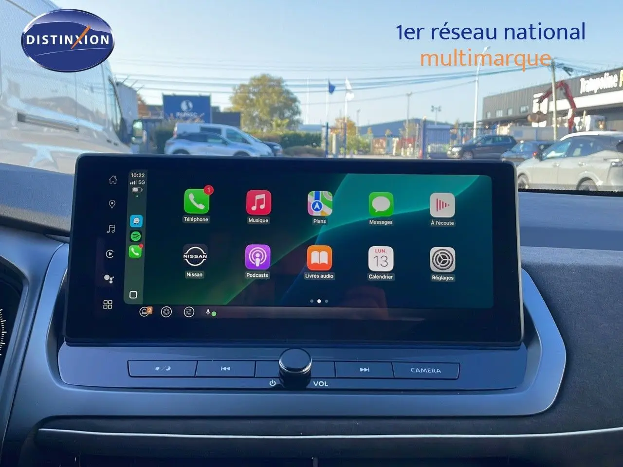 Écran tactile central du tableau de bord du Nissan Qashqai blanc nacré avec toit noir, affichant les applications connectées.