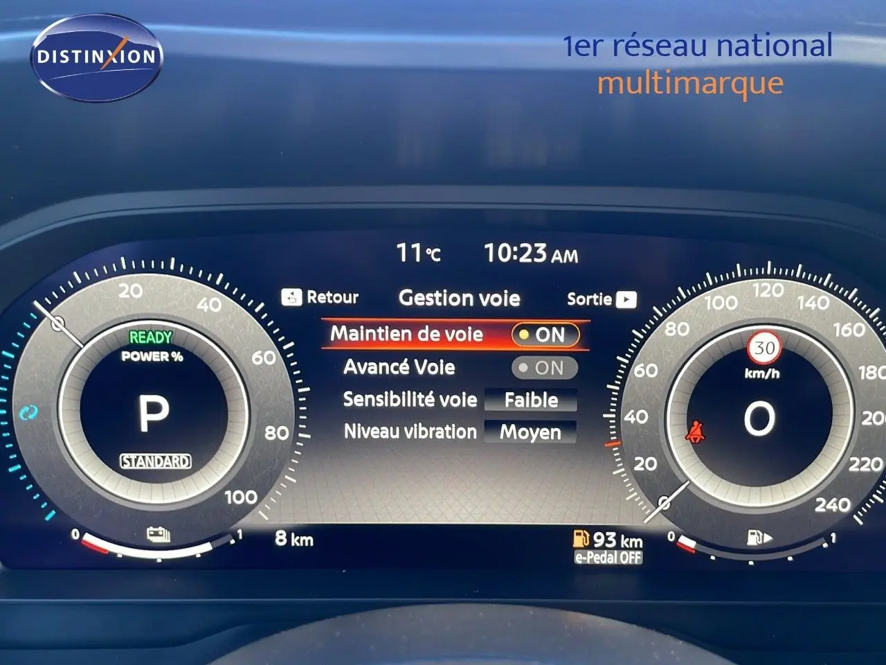 Tableau de bord numérique du Nissan Qashqai blanc nacré, affichant la gestion des aides à la conduite et la vitesse à 0 km/h.