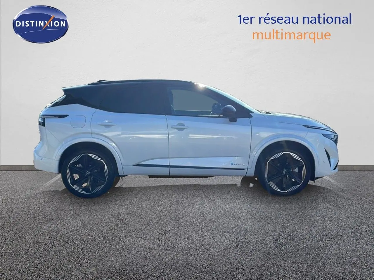 Profil droit du Nissan Qashqai blanc nacré à toit noir, avec jantes noires et lignes modernes visibles.