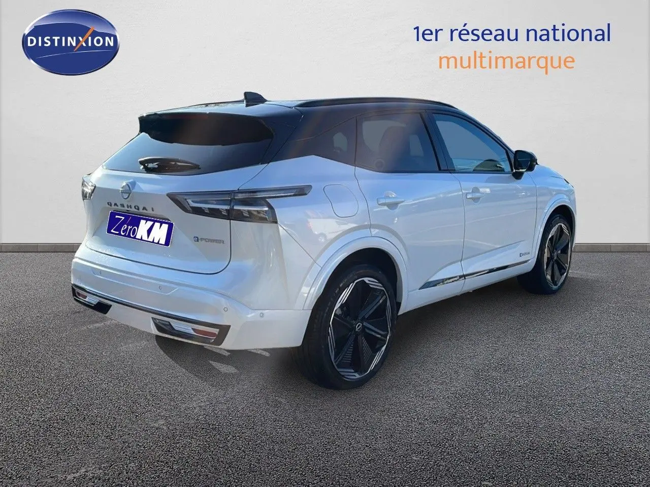 Vue 3/4 arrière droite du Nissan Qashqai blanc nacré à toit noir, soulignant ses feux LED et ses jantes noires distinctives.