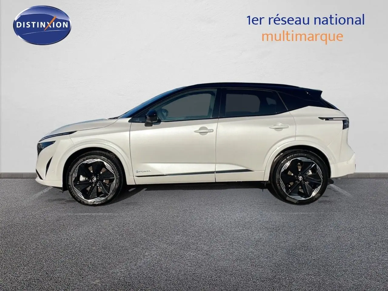 Nissan Qashqai blanc nacré avec toit noir en profil droit, soulignant ses jantes noires distinctives.