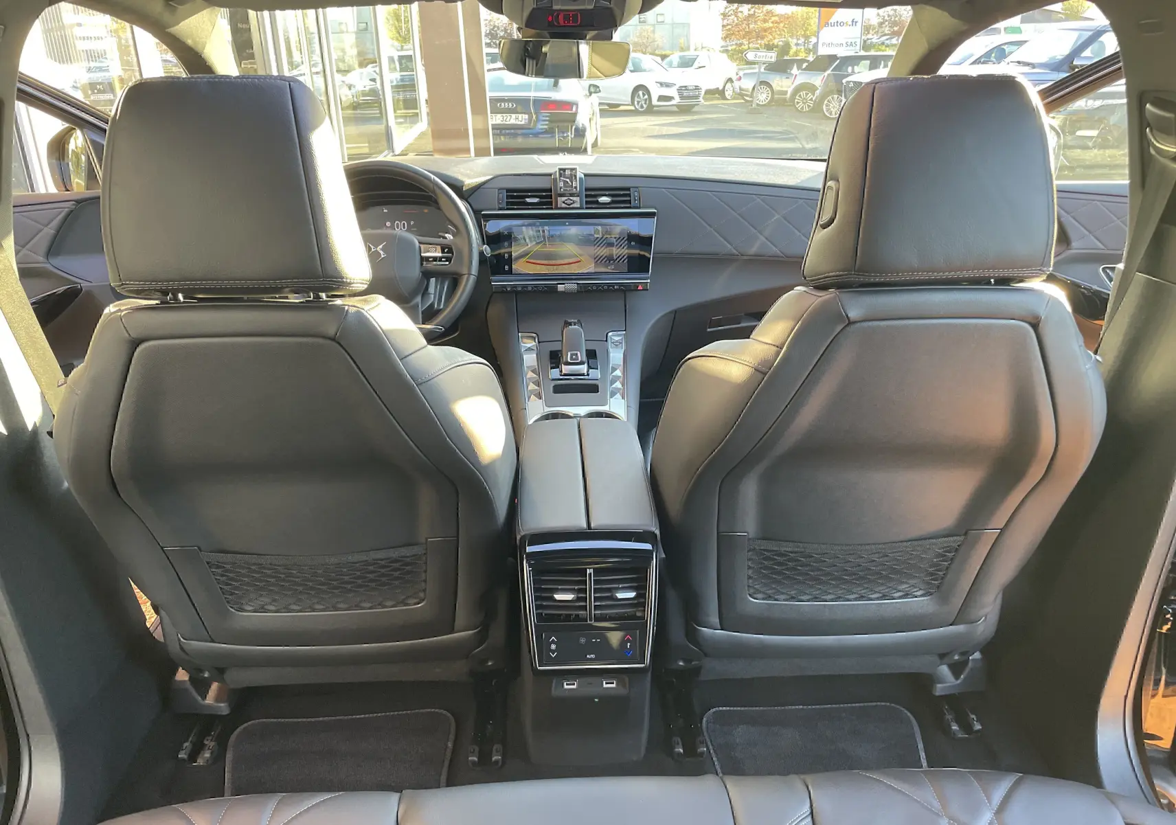 Vue arrière de l'habitacle noir cuir du DS7 2024, mettant en valeur les sièges avant et la console centrale moderne.