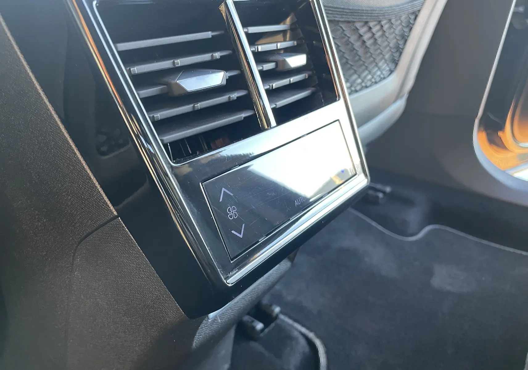 Détail des bouches d'aération arrière avec commandes de climatisation tactile dans un DS7 2024 noir Perla Nera.