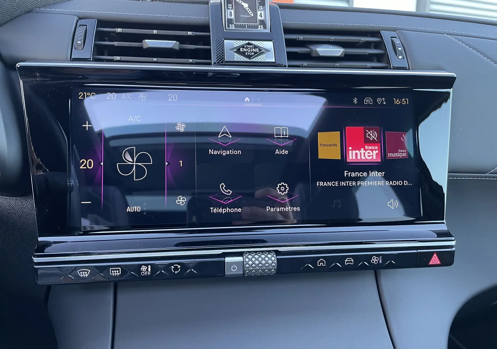 Écran tactile central du tableau de bord du DS7 2024 noir Perla Nera, affichant la climatisation et la radio France Inter.
