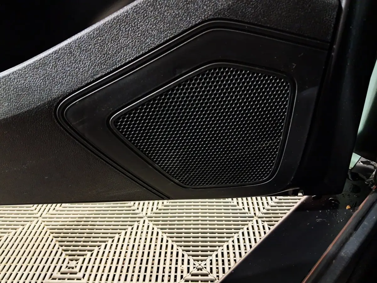 Gros plan sur le haut-parleur intégré à la porte côté conducteur de l'AIXAM MINAUTO E chic 2025 vert électrique.