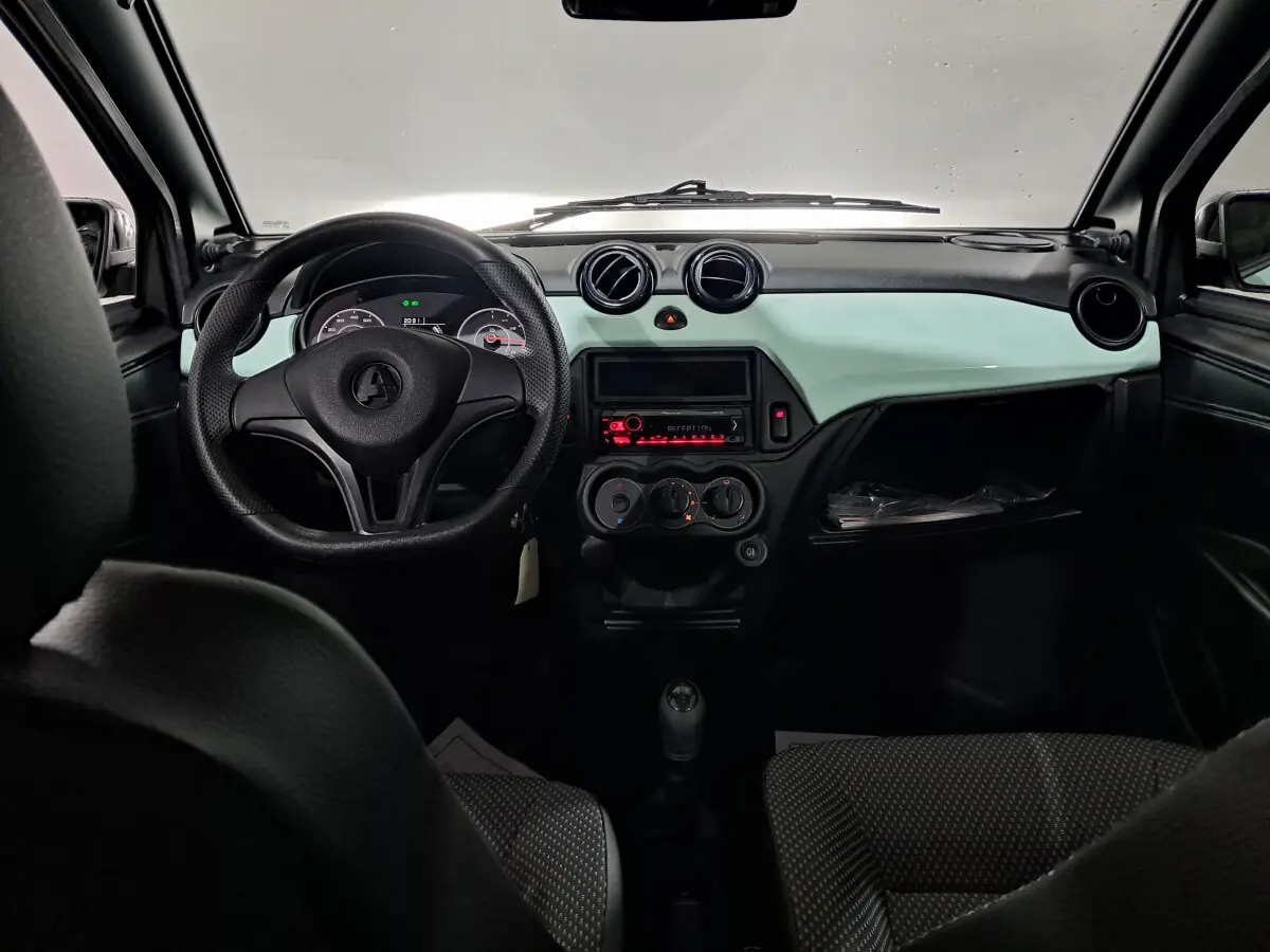 Vue intérieure avant de l'AIXAM MINAUTO E chic 2025, tableau de bord vert clair avec volant noir et commandes centrales.