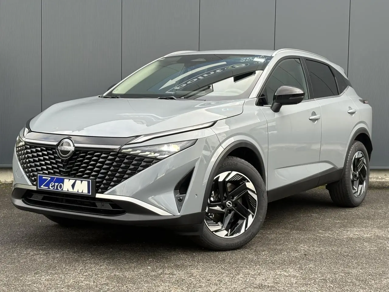 Nissan Qashqai III e-Power gris Ceramic, vue 3/4 avant droit, avec calandre noire et jantes alliage stylisées.