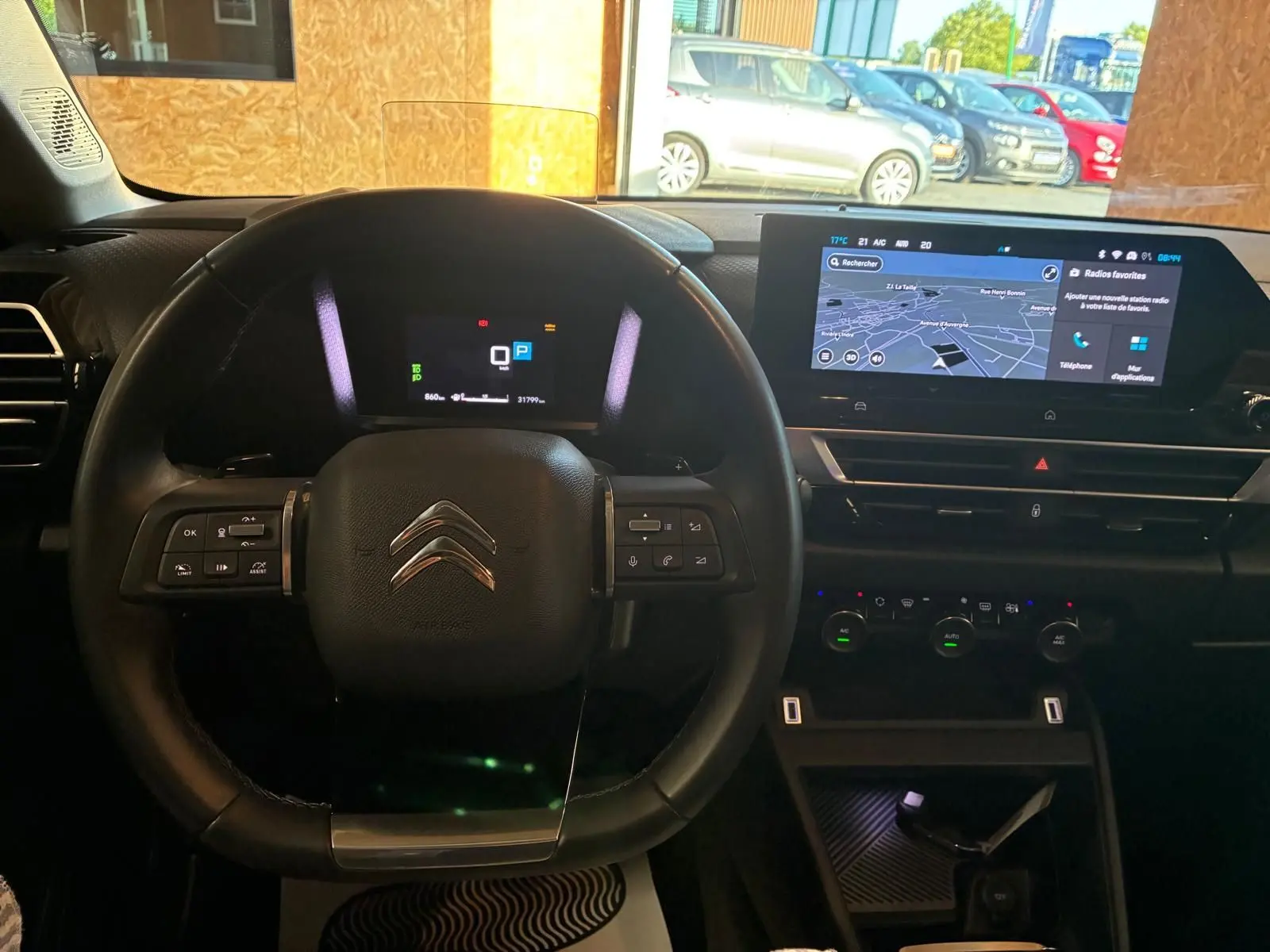 Vue intérieure centrée sur le volant et le tableau de bord numérique du Citroën C4 X gris 2024 avec écran tactile GPS.