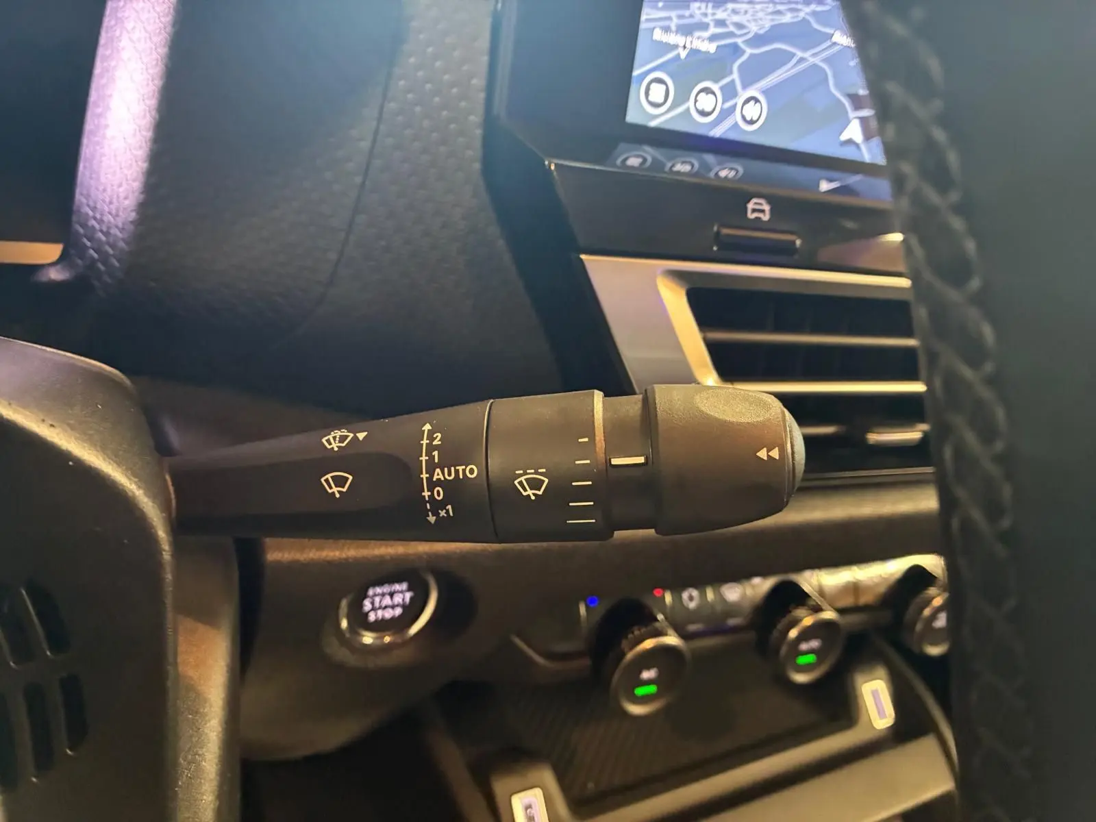 Gros plan sur la commande d’essuie-glace à gauche du volant dans l’habitacle gris-noir du Citroën C4 X 2024.