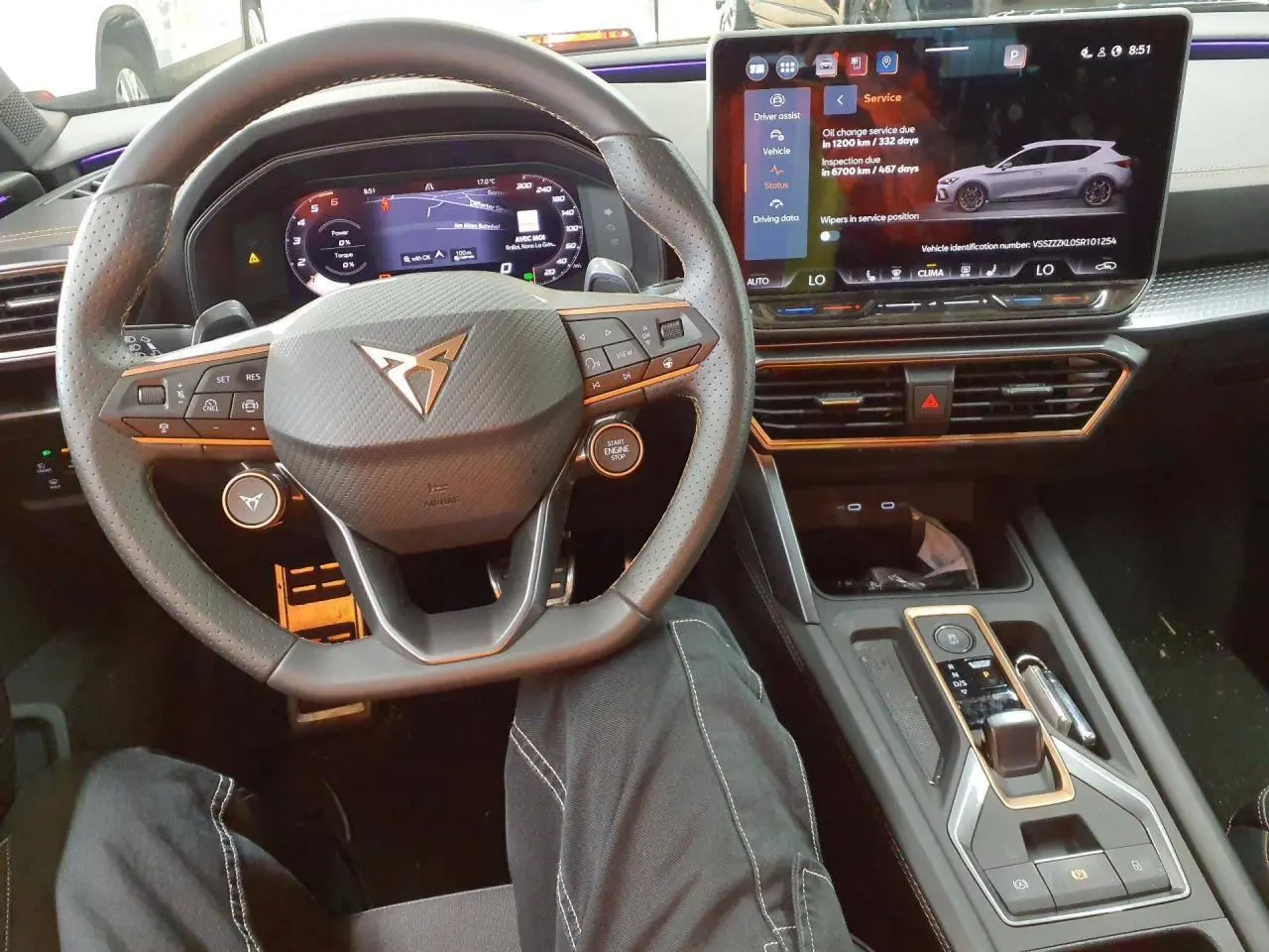 Vue intérieure centrée sur le volant cuir perforé et l'écran tactile du tableau de bord de la CUPRA Leon 2025.