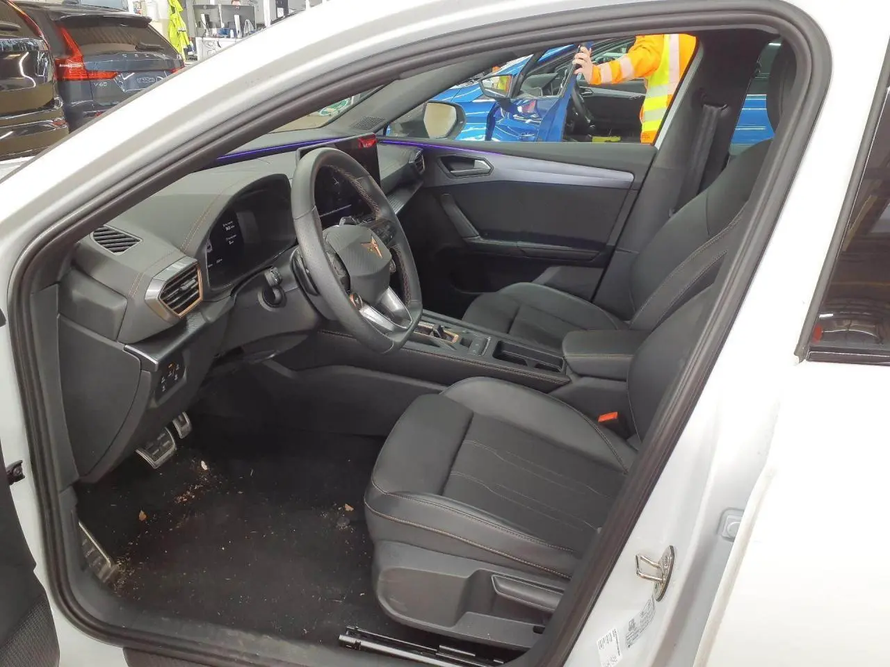 Intérieur de la CUPRA Leon blanc Nevada vu côté conducteur, avec sièges noirs et volant cuir Supersports.