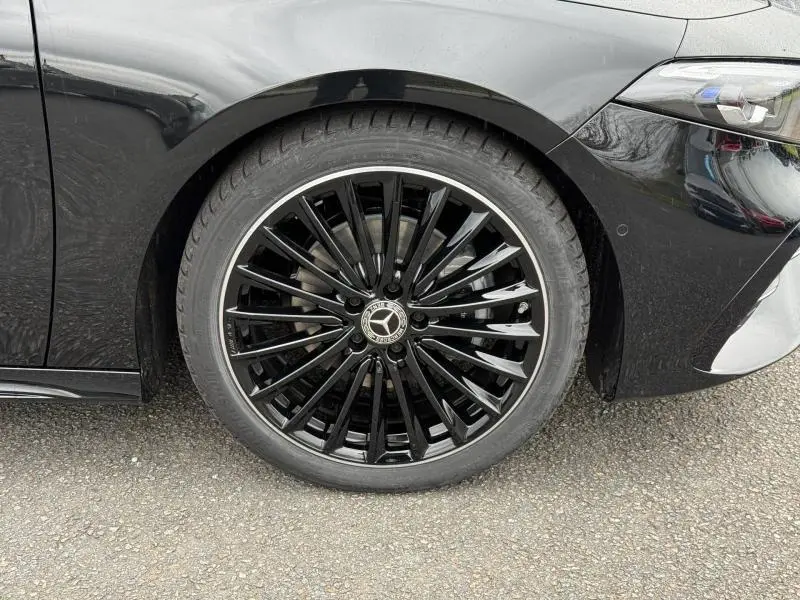 Gros plan sur la roue avant gauche noire brillante avec jante AMG de la Mercedes Classe A gris montagne métallisé.