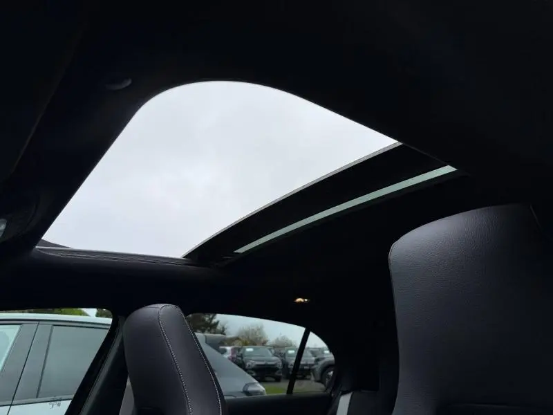 Toit ouvrant panoramique ouvert vu de l'intérieur arrière d'une Mercedes Classe A gris montagne métallisé.