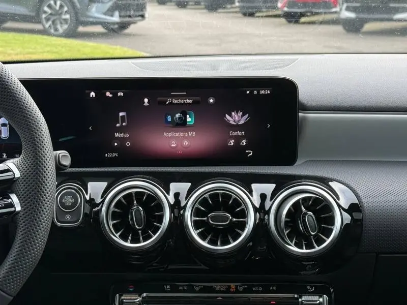 Vue intérieure du tableau de bord de la Mercedes Classe A 200 d AMG Line 2026, avec écran tactile et aérateurs ronds noirs brillants.
