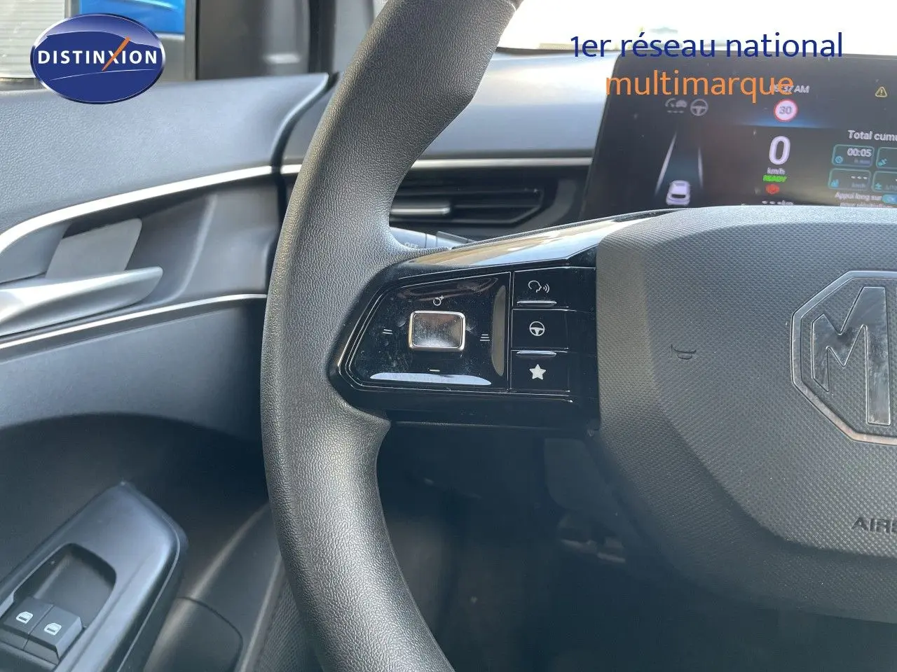 Gros plan sur le volant noir du MG3 2024 bleu como, montrant les commandes à gauche et le tableau de bord digital.