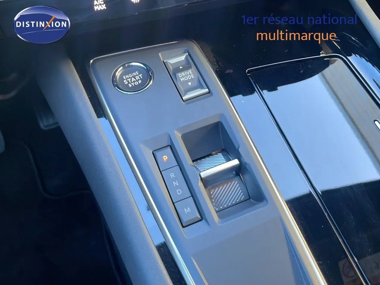 Gros plan sur la console centrale noire brillante de la Peugeot 508 SW 2024, avec boutons de démarrage et sélection de mode de conduite.