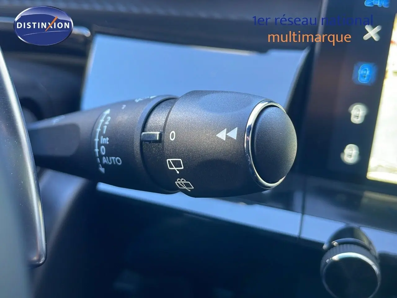 Gros plan sur la commande d'essuie-glace à gauche du volant dans l'habitacle d'une Peugeot 508 SW noir Perla Metal 2024.