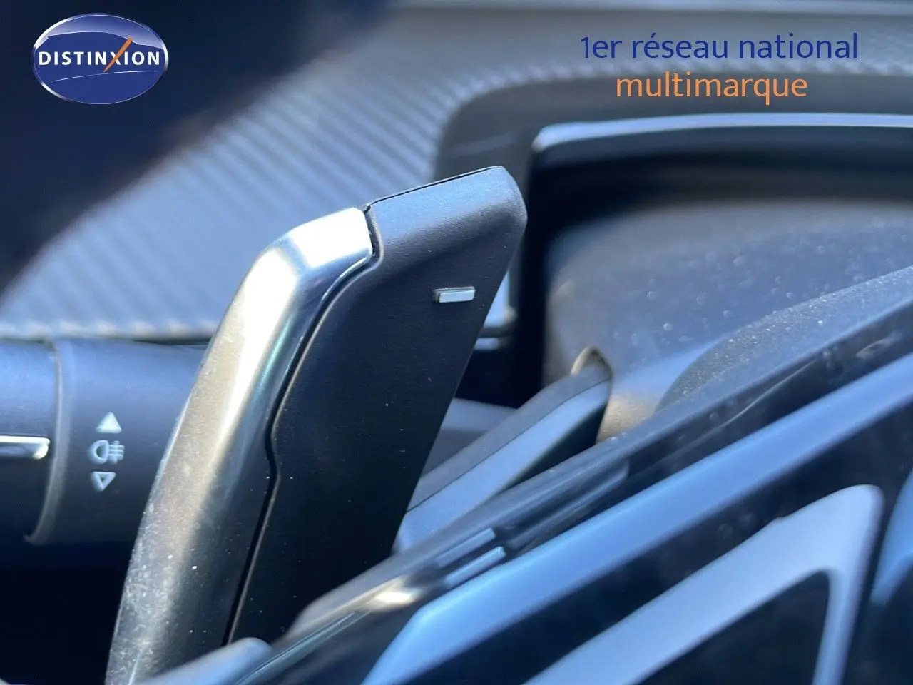 Le levier de commande au volant d'une Peugeot 508 SW noire, avec détails du tableau de bord en arrière-plan.