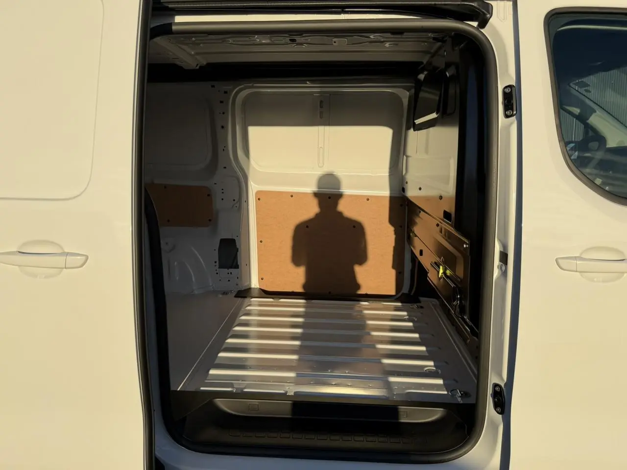 Vue intérieure arrière du Citroën Jumpy XL blanc Icy, montrant l'espace de chargement vide avec parois protégées.