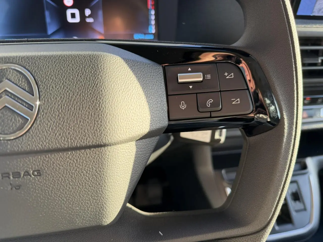 Gros plan sur la partie droite du volant gris du Citroën Jumpy 2025 avec commandes audio et téléphone intégrées.