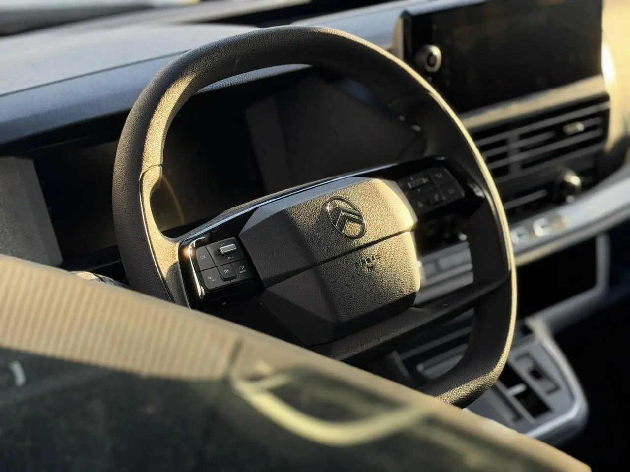 Volant noir Citroën Jumpy 2025 en gros plan avec commandes intégrées, tableau de bord et écran tactile en arrière-plan.