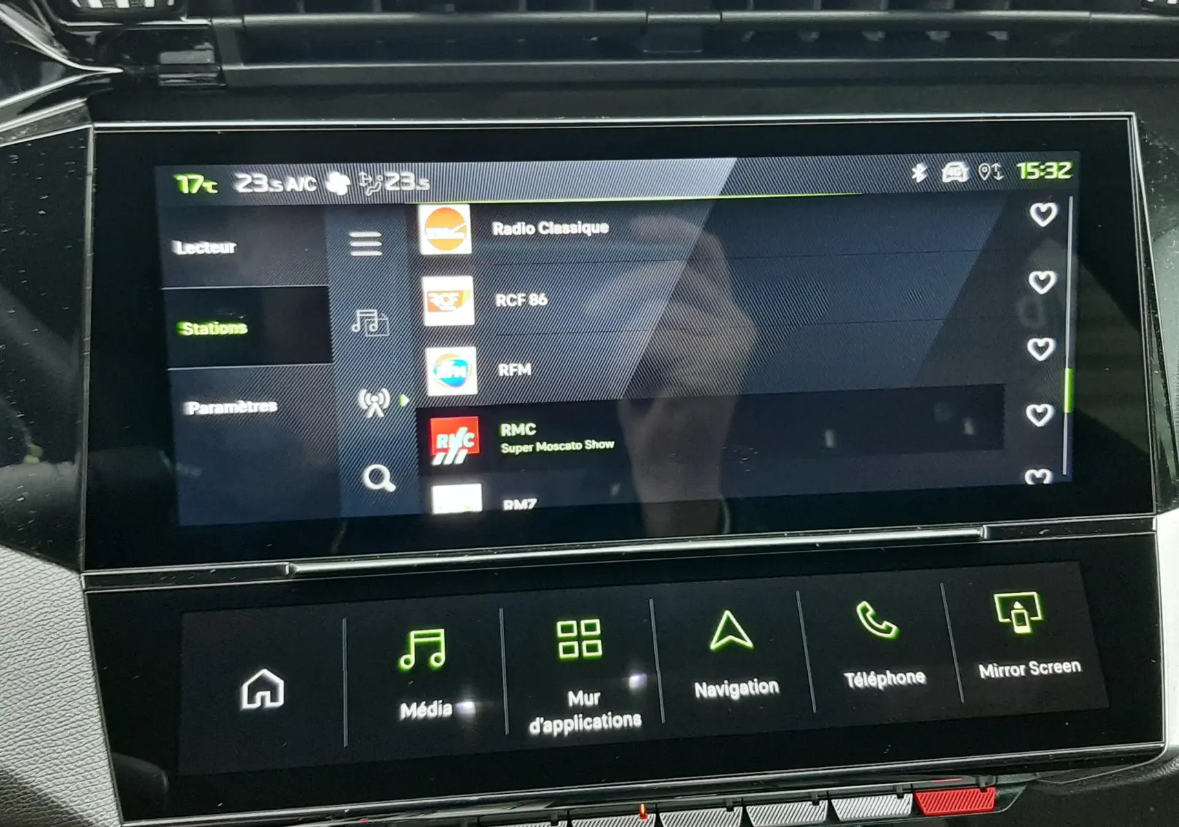 Écran tactile central de la Peugeot 308 Hybrid 2025 affichant les stations radio avec commandes multimédia en dessous.