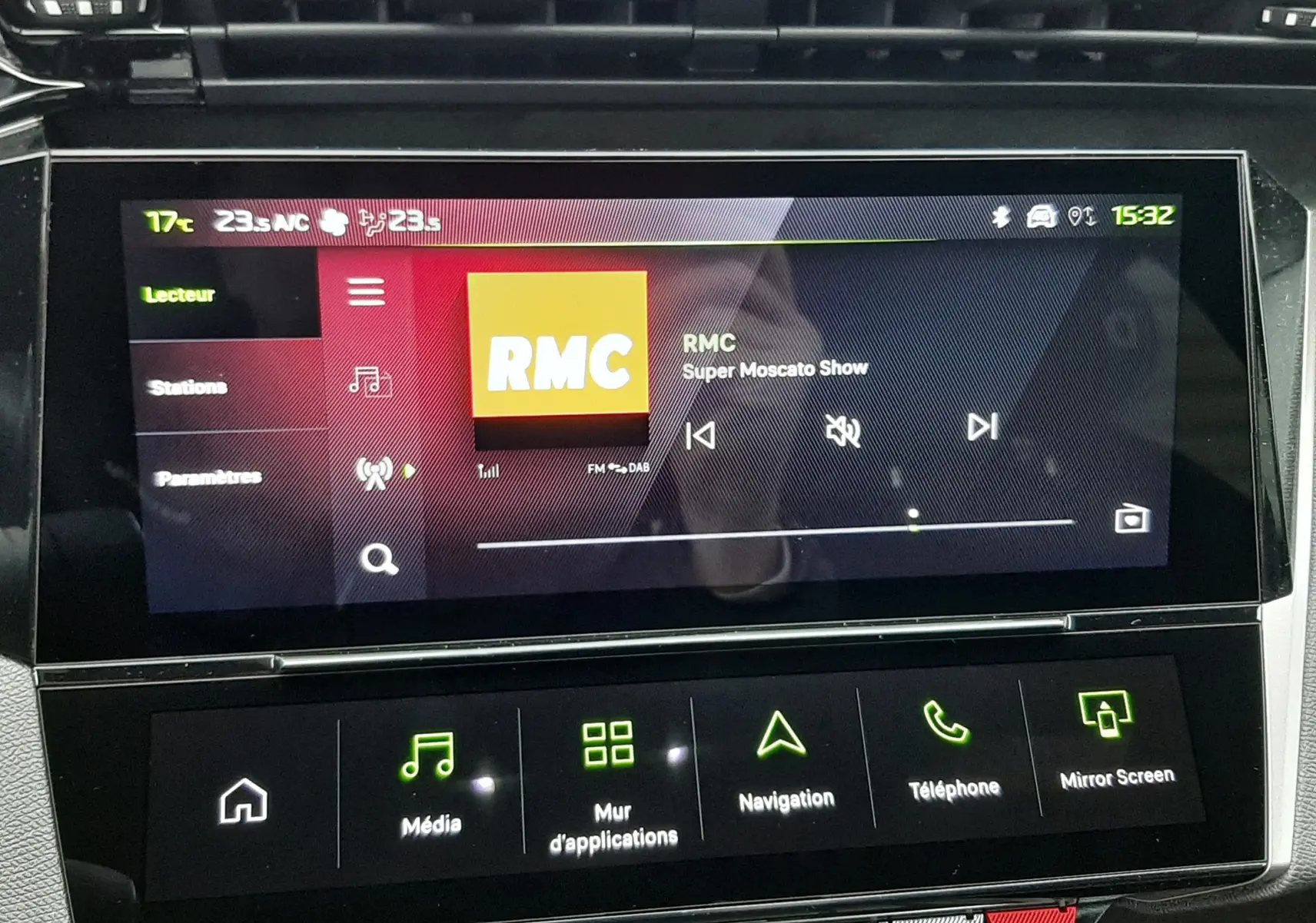 Écran tactile central de la Peugeot 308 1.2 Hybrid GT 2025 affichant la radio RMC dans un intérieur noir moderne.