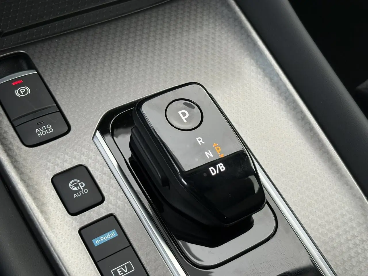 Gros plan sur le sélecteur de boîte automatique noir et les boutons de commande sur la console centrale du Nissan Qashqai gris Ceramic.