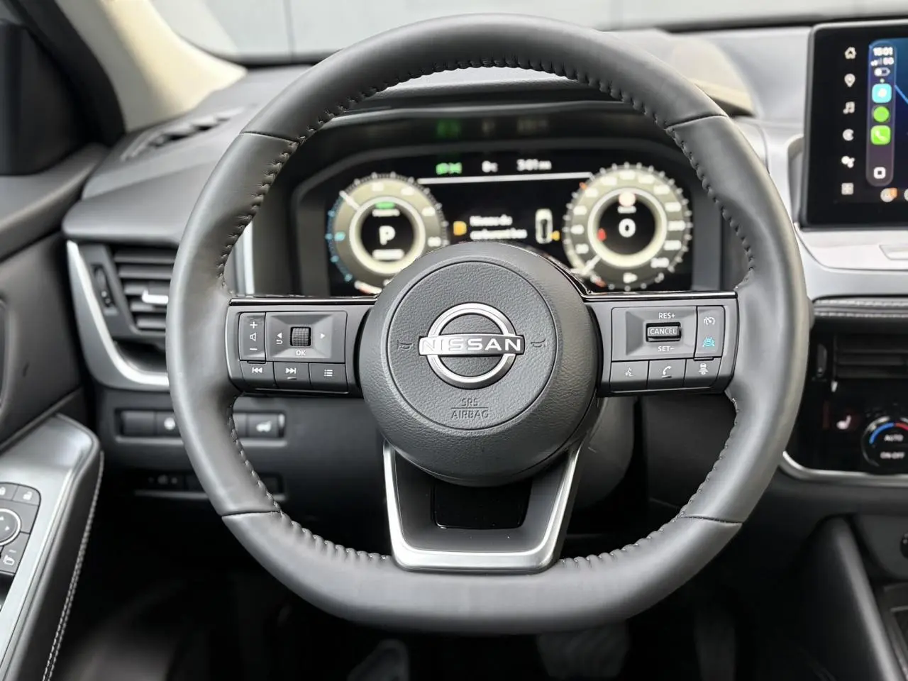 Vue frontale du volant cuir noir du Nissan Qashqai 2025 avec tableau de bord numérique et écran tactile latéral.
