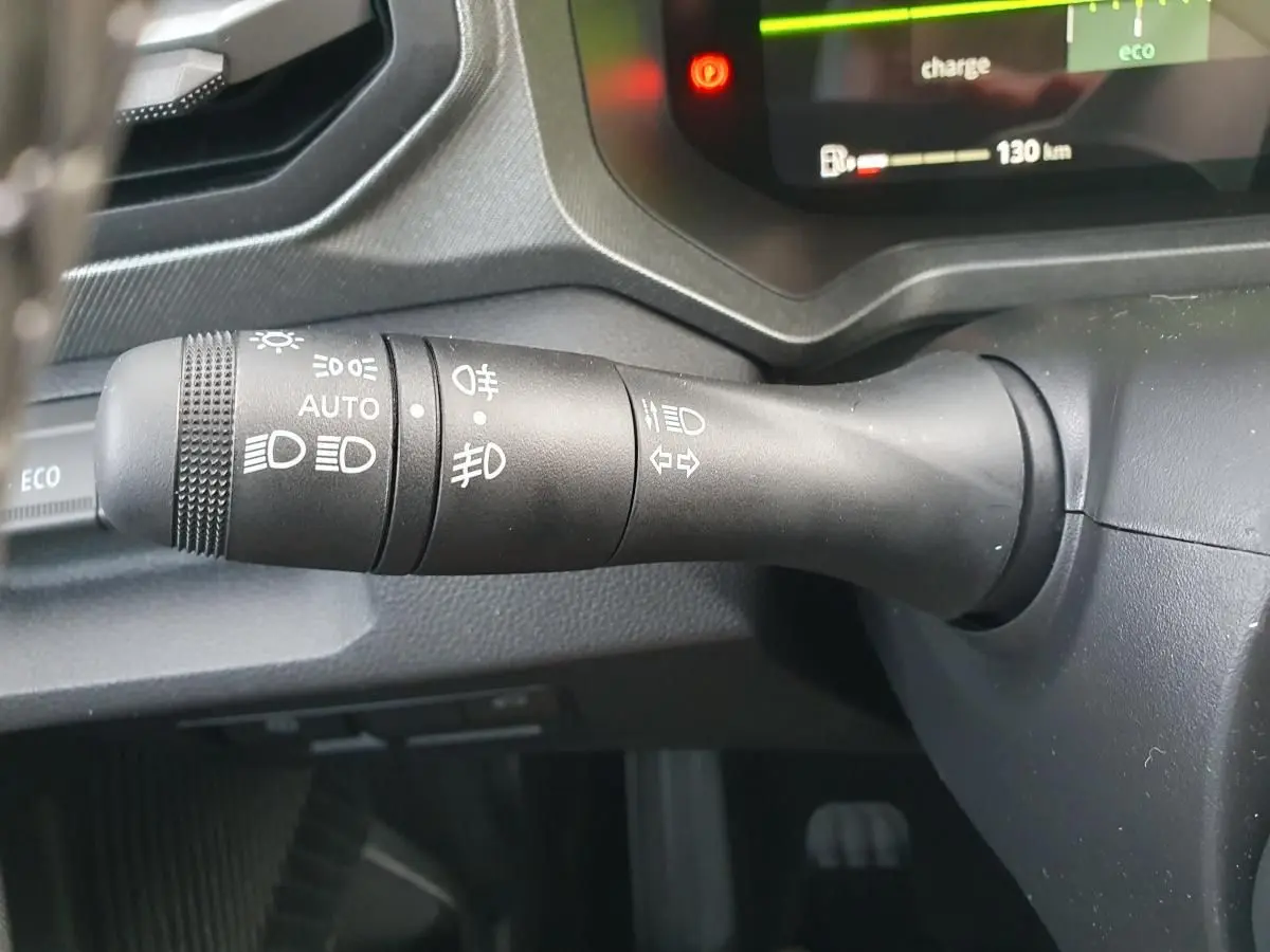 Gros plan sur la commande des feux et clignotants du tableau de bord du Dacia Bigster 2026, intérieur noir.