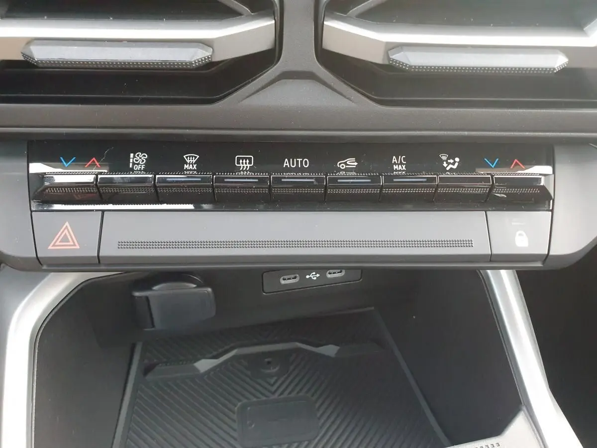 Vue rapprochée de la console centrale du Dacia Bigster 2026, avec commandes climatisation et ports USB-C visibles.