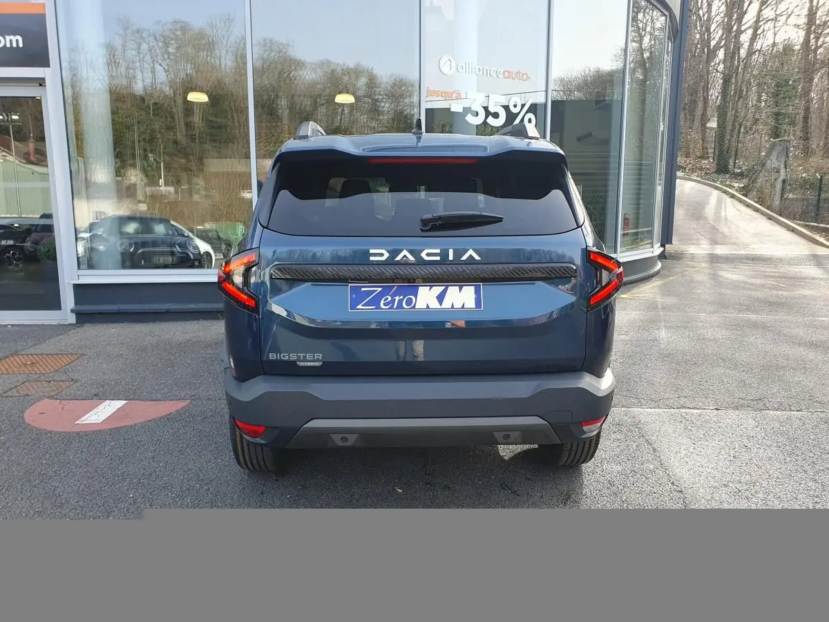 Vue arrière du Dacia Bigster bleu indigo avec feux LED en forme de C et logo DACIA bien visible.