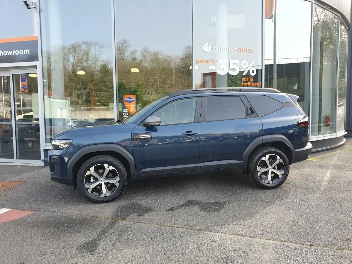Vue de profil côté gauche d’un Dacia Bigster bleu indigo avec jantes alliage 18” et toit panoramique.