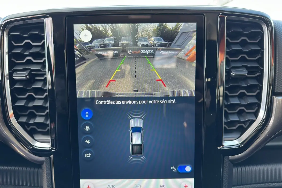 Écran central du Ford Ranger 2025 montrant la caméra de recul avec vue arrière et alertes de sécurité.