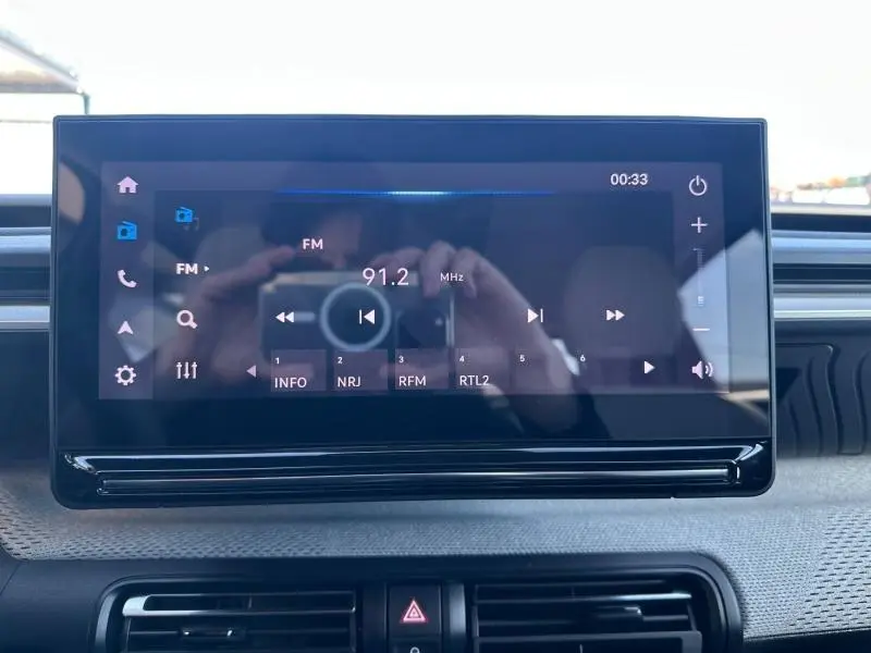 Écran tactile central du tableau de bord de la Citroën C3 2025, affichant la radio FM sur fond noir.