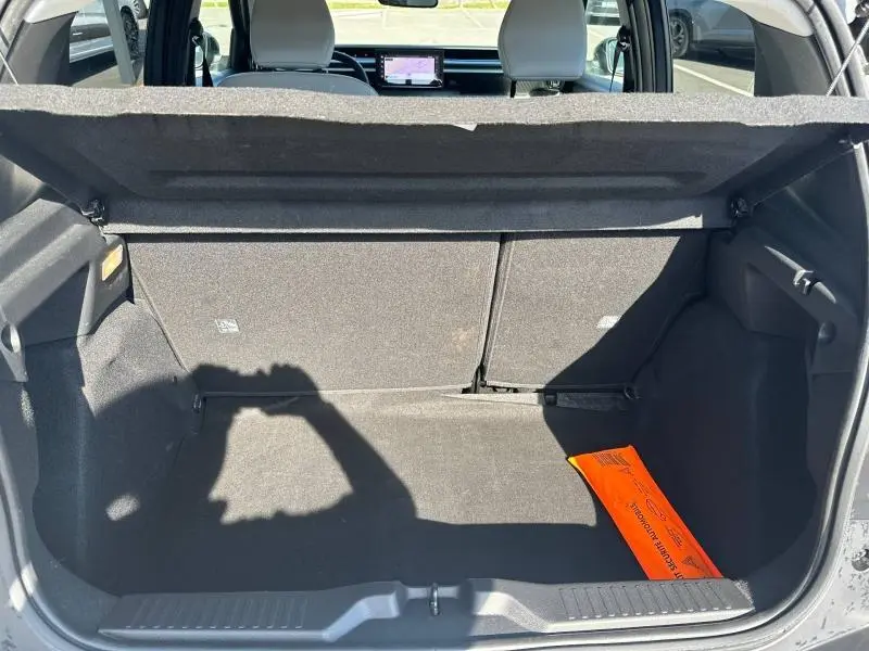 Coffre ouvert vu de l'arrière d'une Citroën C3 noire 2025, avec un triangle de signalisation orange visible à droite.