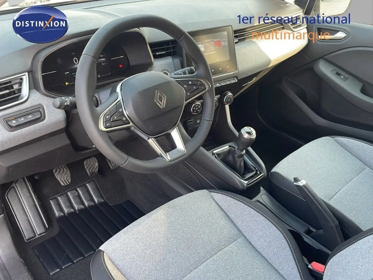 Vue intérieure côté conducteur de la Renault Clio Evolution Blue dCi 100 2025, volant cuir, écran tactile central, sièges gris clair.