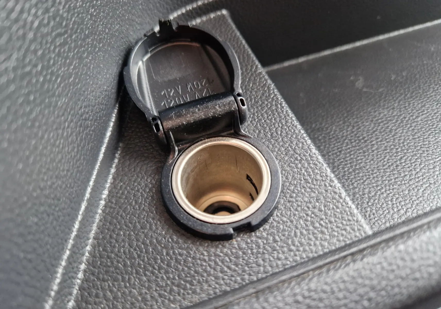 Prise allume-cigare ouverte en gros plan sur la console intérieure noire du Renault Master L2H2 blanc 2024.