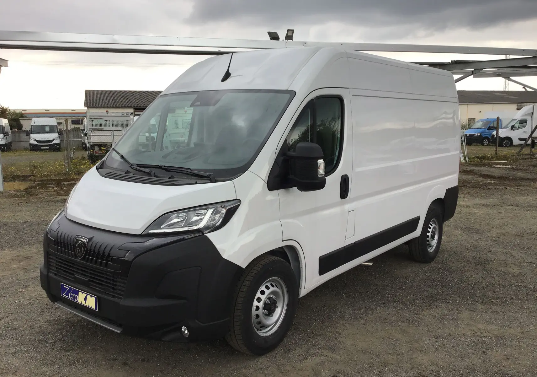 Peugeot Boxer Fourgon blanc vu en 3/4 avant droit, avec pare-chocs noir et calandre distinctive.